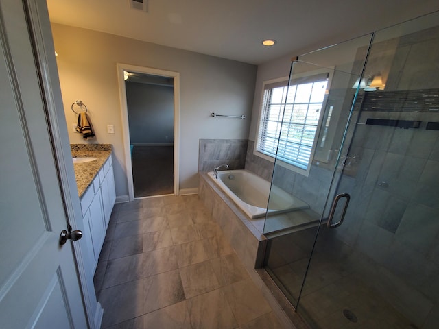 full bathroom with a stall shower, vanity, a bath, and baseboards