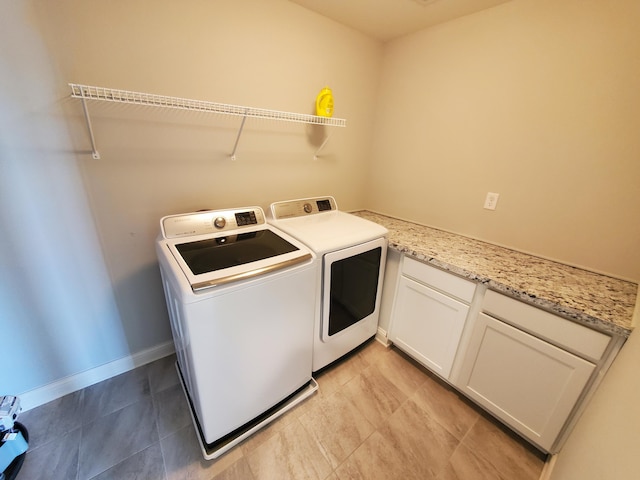 laundry room with washer and dryer, cabinet space, baseboards, and light tile patterned floors