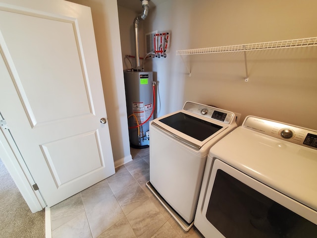 laundry room with washing machine and dryer, laundry area, water heater, and light tile patterned floors