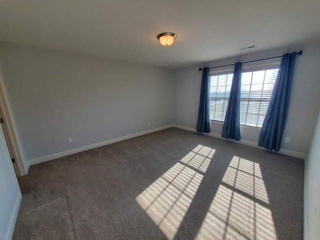 unfurnished room featuring carpet flooring, visible vents, and baseboards