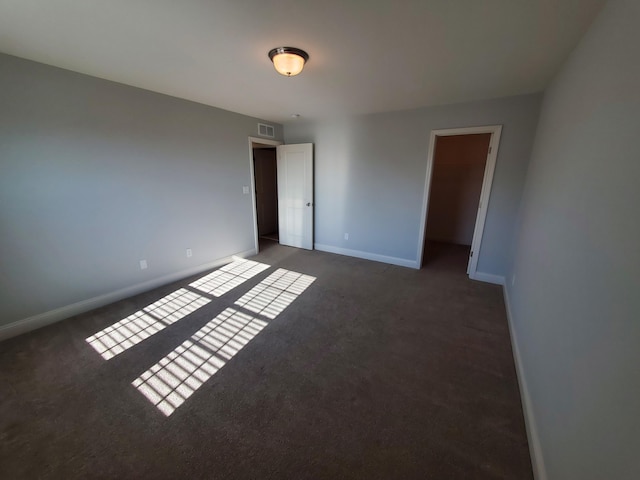 carpeted empty room with visible vents and baseboards