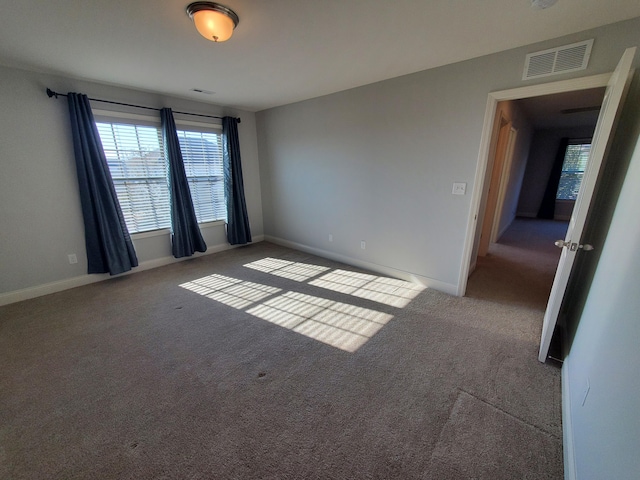 carpeted empty room with visible vents and baseboards