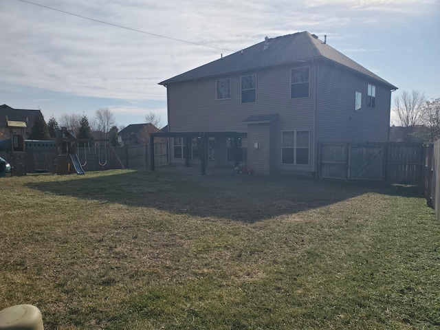 back of property featuring a lawn, a playground, and a fenced backyard