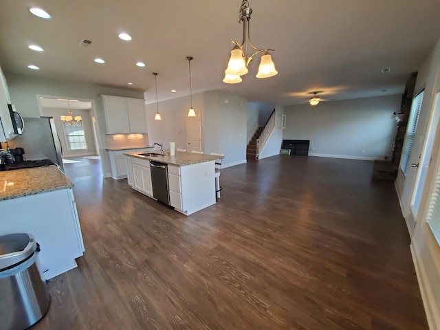 kitchen featuring a kitchen island with sink, ceiling fan with notable chandelier, a sink, white cabinetry, and appliances with stainless steel finishes