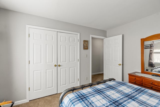 carpeted bedroom featuring baseboards and a closet