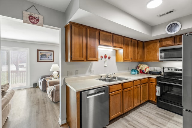 kitchen with visible vents, appliances with stainless steel finishes, light countertops, light wood-type flooring, and a sink