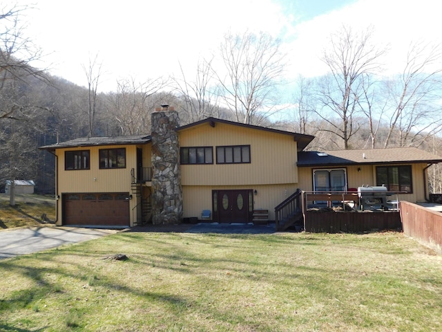 view of front of property featuring a garage, concrete driveway, a chimney, a deck, and a front yard