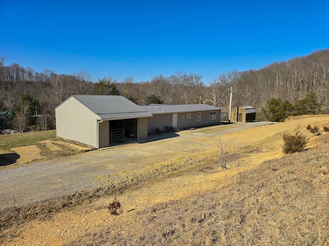 exterior space with an outbuilding, metal roof, and an outdoor structure