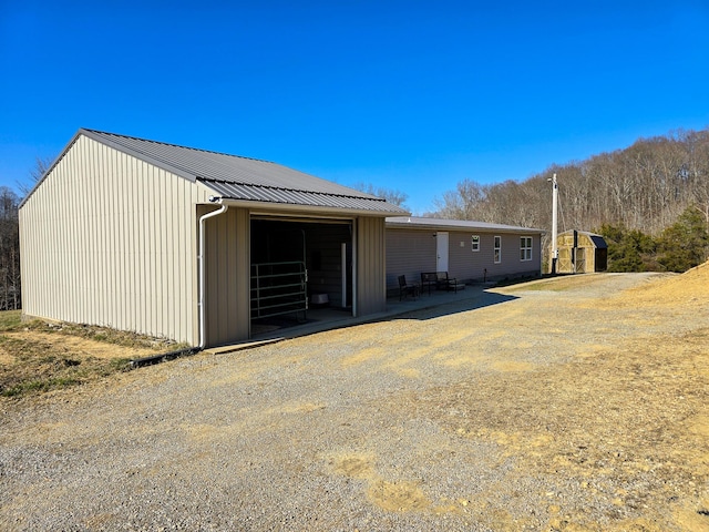 view of side of property with an outbuilding and metal roof