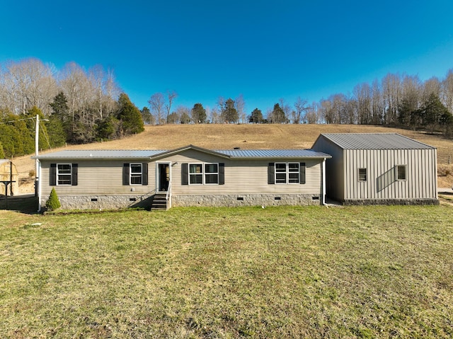 back of house with crawl space, metal roof, and a yard