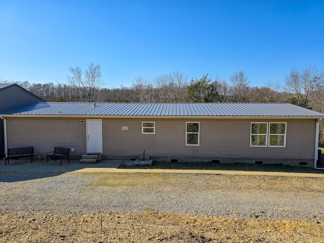 back of property featuring entry steps, crawl space, a patio area, and metal roof