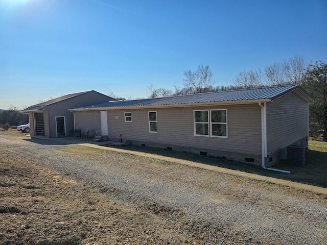 view of front facade featuring metal roof, crawl space, and cooling unit