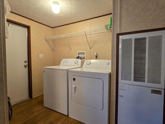 washroom featuring dark wood finished floors, washing machine and clothes dryer, ornamental molding, a textured ceiling, and laundry area