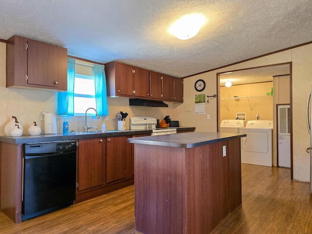 kitchen featuring dishwasher, electric stove, dark countertops, washing machine and dryer, and a sink