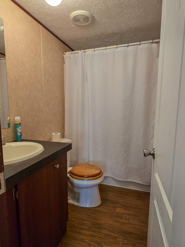 bathroom featuring visible vents, toilet, wood finished floors, a textured ceiling, and vanity