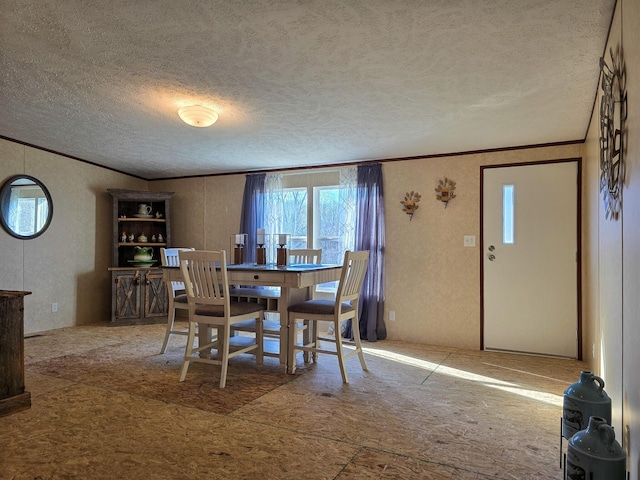 dining space with ornamental molding and a textured ceiling