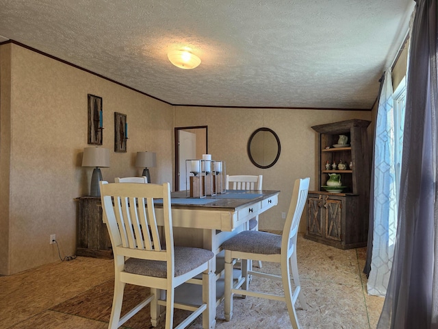 dining room featuring a textured ceiling and crown molding