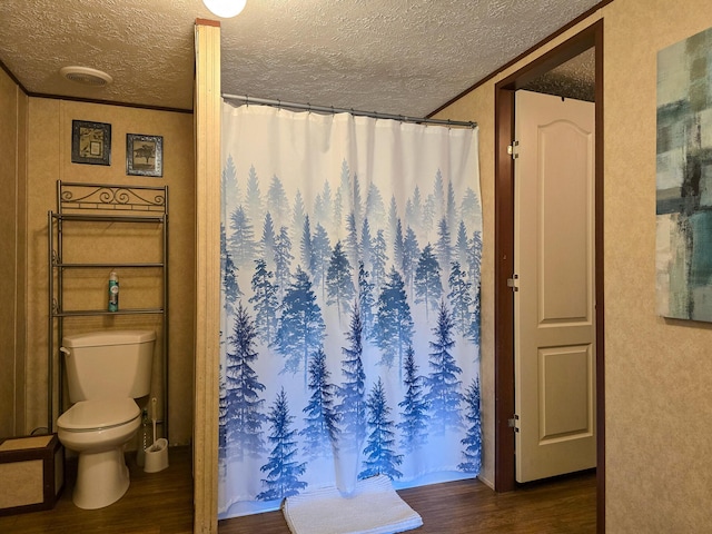 full bath featuring a textured ceiling, toilet, wood finished floors, visible vents, and a shower with curtain