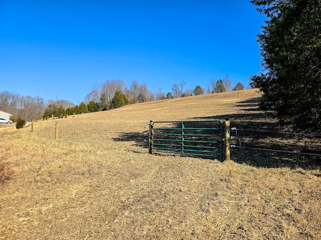 view of yard featuring fence and a rural view