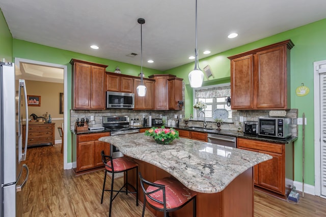 kitchen featuring appliances with stainless steel finishes, a sink, visible vents, and decorative backsplash