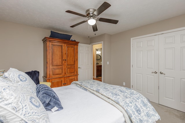 bedroom with light carpet, a closet, a textured ceiling, and a ceiling fan