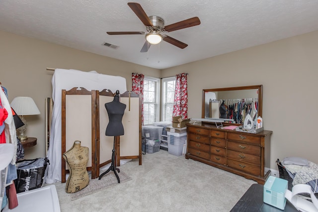 carpeted bedroom with ceiling fan, visible vents, and a textured ceiling