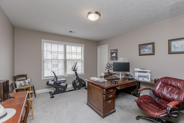 office with visible vents, light carpet, a textured ceiling, and baseboards