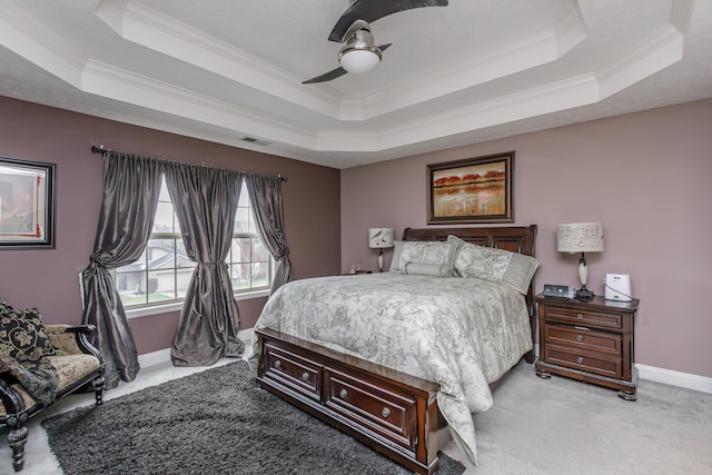 bedroom with light carpet, visible vents, baseboards, a raised ceiling, and crown molding