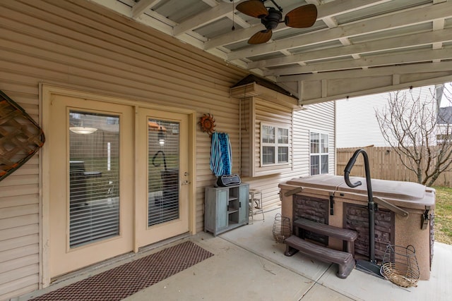 view of patio with fence, a hot tub, and ceiling fan