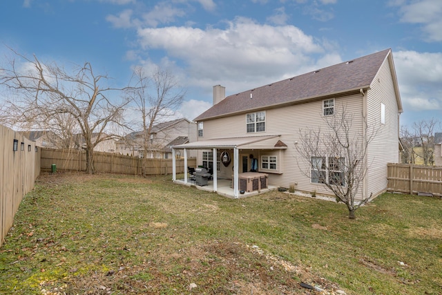 rear view of house with a yard, a patio area, and a fenced backyard