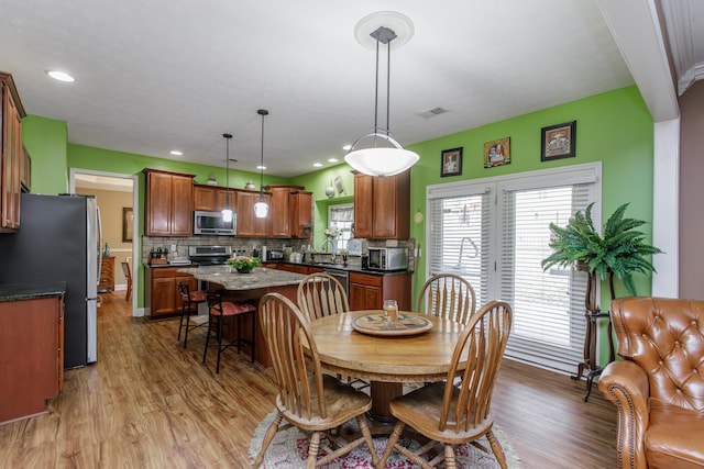 dining room with light wood-type flooring, visible vents, and recessed lighting