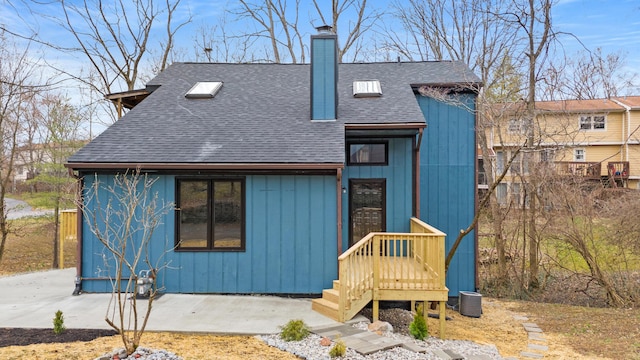 chalet / cabin with roof with shingles and a chimney