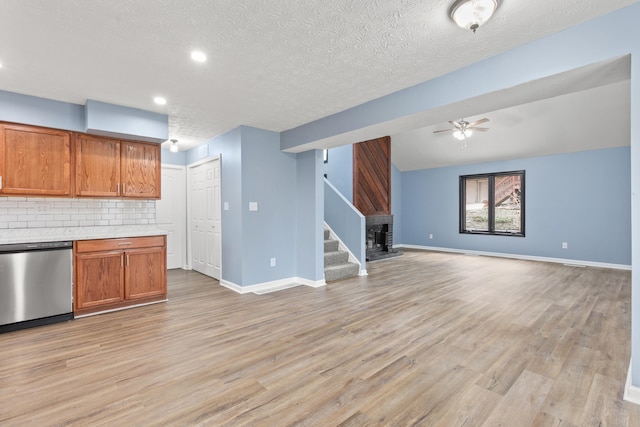 kitchen with tasteful backsplash, dishwasher, light wood-style flooring, brown cabinets, and light countertops