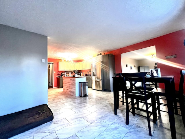 dining room with a textured ceiling and marble finish floor