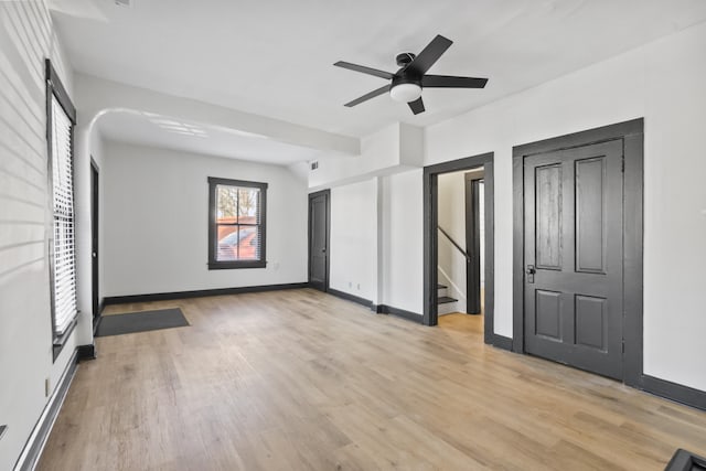 unfurnished bedroom with baseboards, a ceiling fan, and light wood-style floors