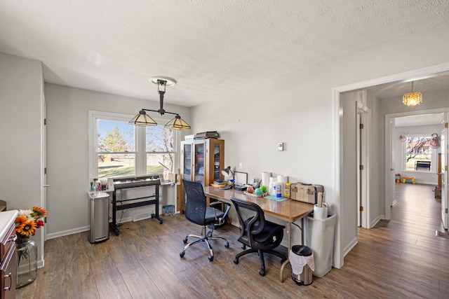 office with a textured ceiling, baseboards, and wood finished floors