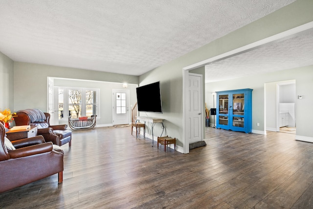 living area featuring dark wood-style floors, a textured ceiling, and baseboards