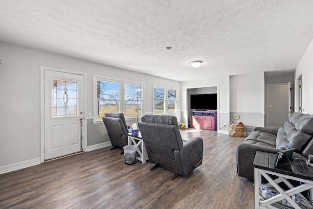 living area featuring dark wood-style floors, baseboards, and a textured ceiling