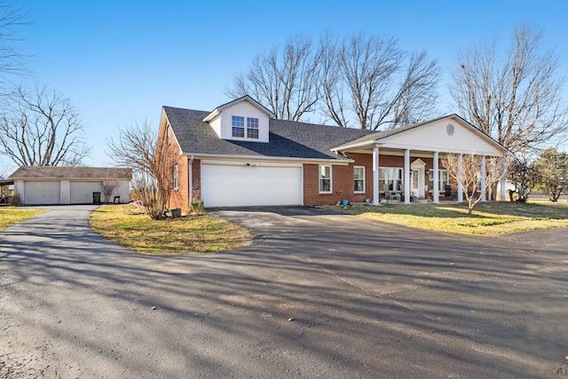 view of front facade featuring a garage, brick siding, a porch, and a shingled roof