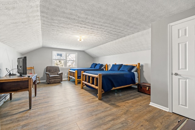 bedroom featuring lofted ceiling, wood finished floors, and baseboards