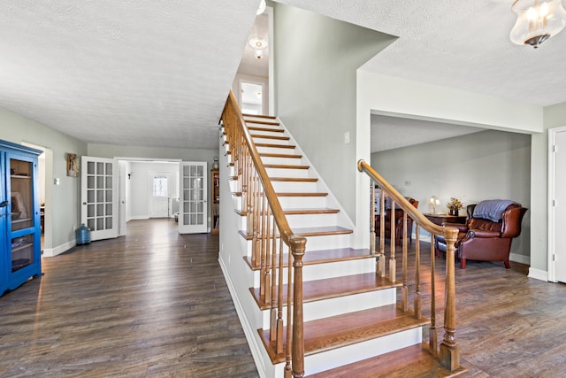 stairs featuring a textured ceiling, french doors, wood finished floors, and baseboards