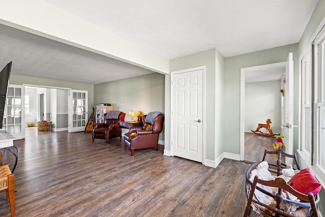 sitting room with french doors, wood finished floors, and baseboards