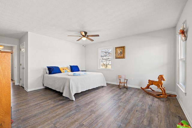 bedroom with ceiling fan, a textured ceiling, baseboards, and wood finished floors