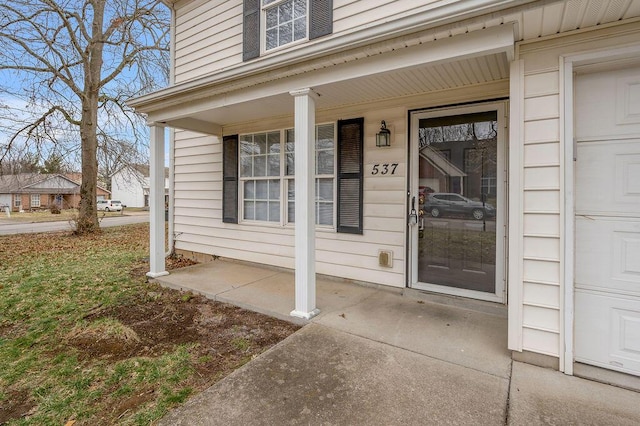 doorway to property featuring a garage and covered porch