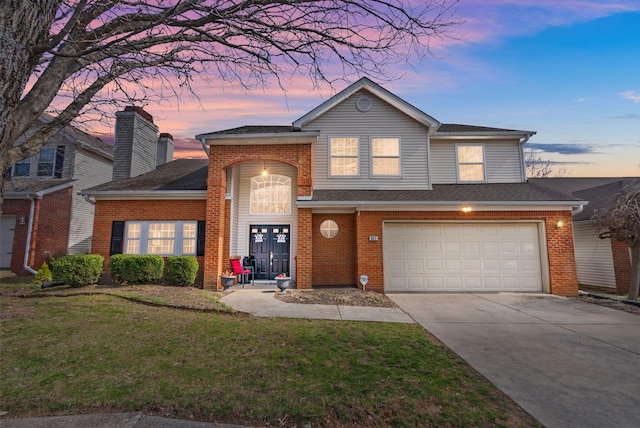 traditional home featuring a yard, brick siding, concrete driveway, and an attached garage