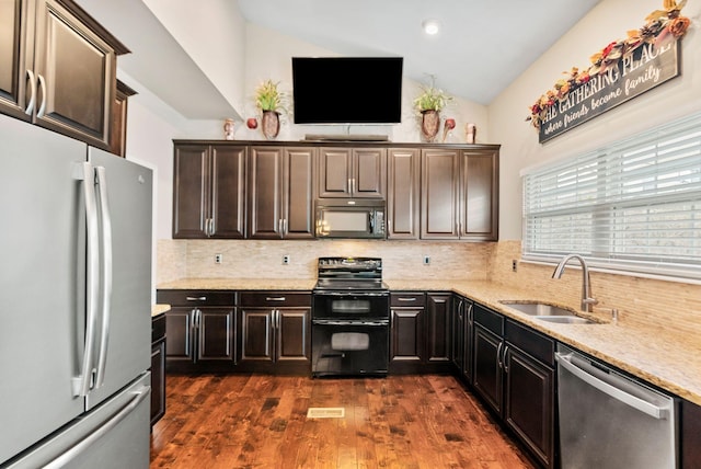 kitchen featuring dark wood-type flooring, black appliances, a sink, tasteful backsplash, and vaulted ceiling