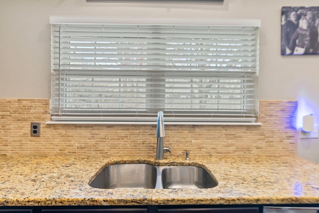 interior details with light stone countertops, tasteful backsplash, and a sink