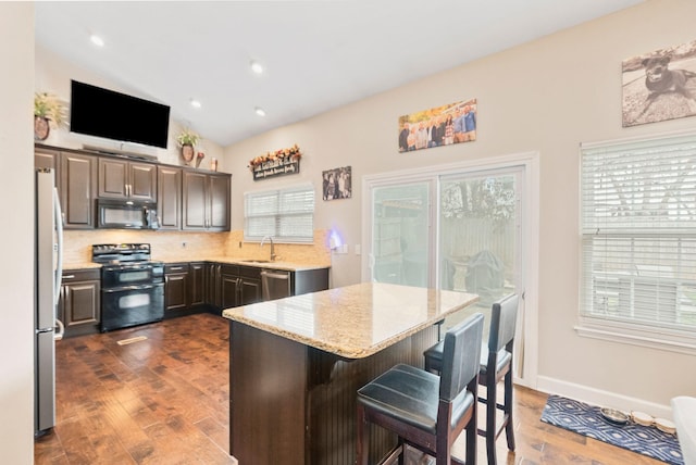 kitchen featuring a sink, lofted ceiling, dark wood-type flooring, and black appliances