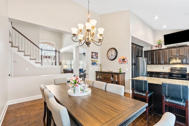 dining space featuring dark wood-type flooring, baseboards, a chandelier, stairs, and high vaulted ceiling