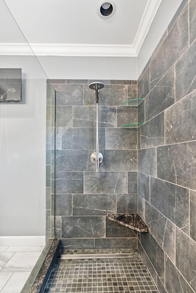 bathroom featuring tiled shower and ornamental molding